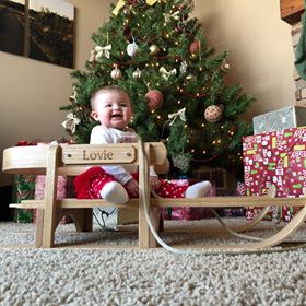 baby on wooden pull sled