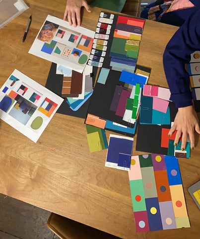 Tia Cibani and Lisa Ritson have color cards splayed all out over the table so they can pick and choose the best colors