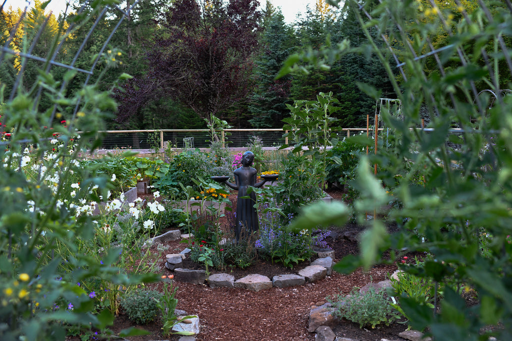 raised bed flower garden with statue in the center