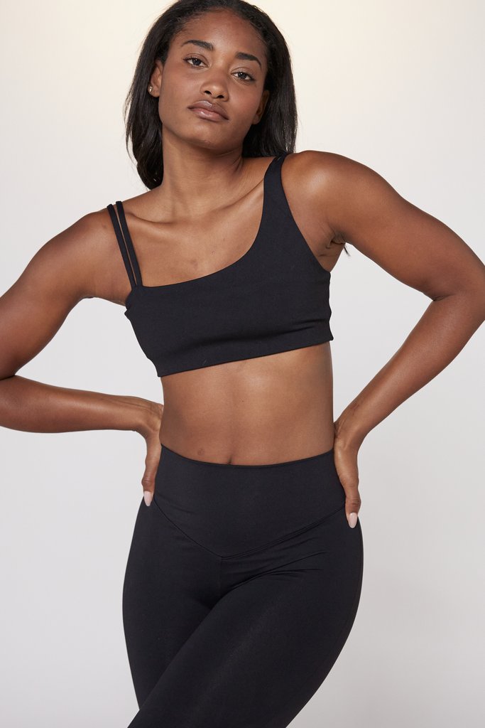 Graceful fit ballerina in black sports bra and leggings stretches with  splits at the ballet barre during a Pilates class in the studio. Embracing  a healthy and sportive lifestyle. 26847156 Stock Photo at Vecteezy