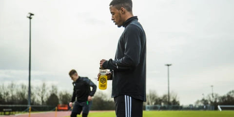Footballer on pitch with hydration drink