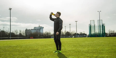 Footballer hydrating after training