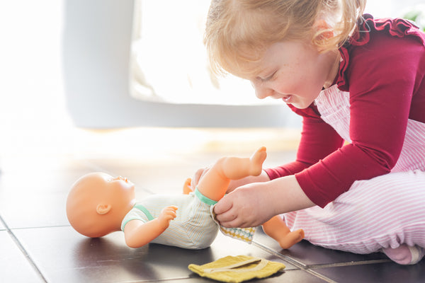 Toddler changing nappy on Djeco Pomea doll