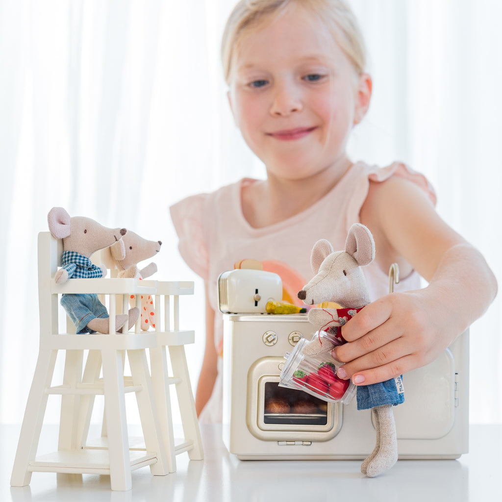 Girl playing with Maileg mice and furniture