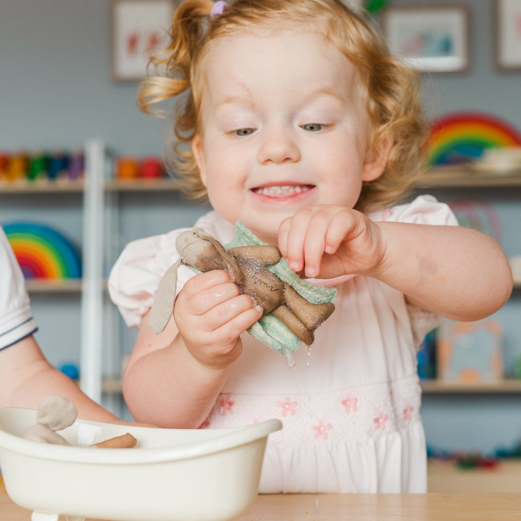 Little girl washing her Maileg mice with joy on her face