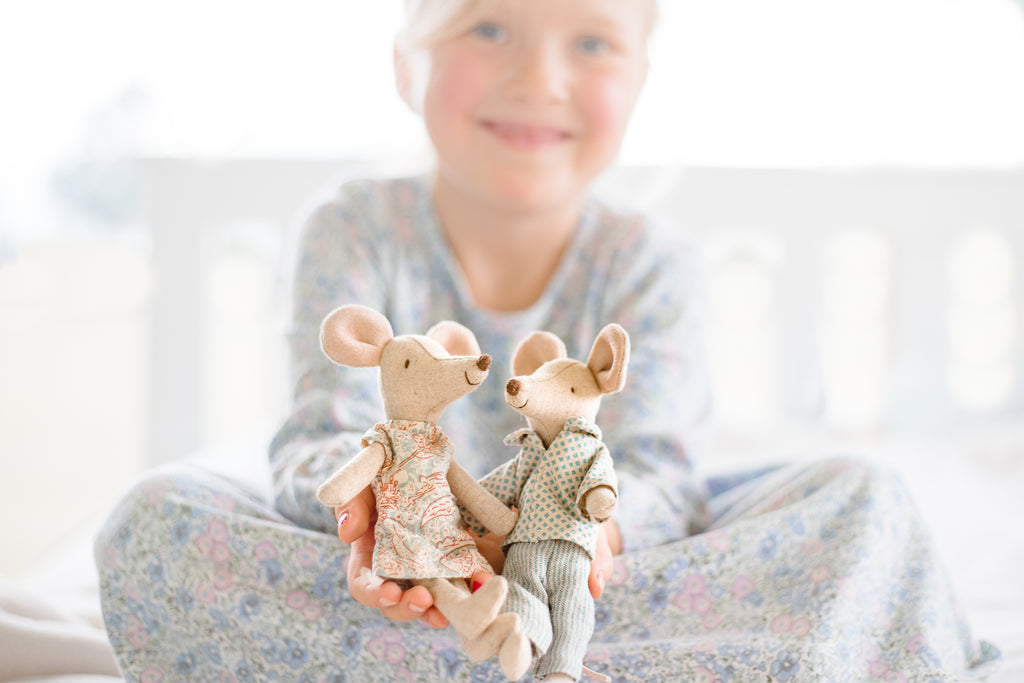 Child smiling holding two Maileg mouse 