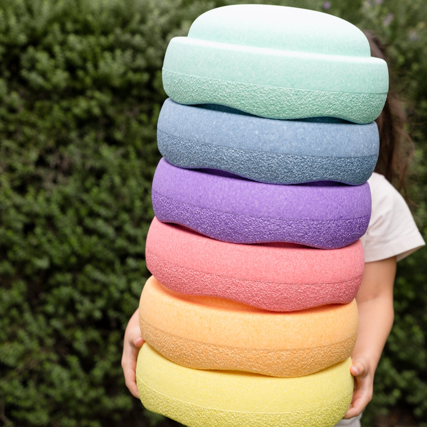 Child carrying stacked Stapelstein pastel stones 