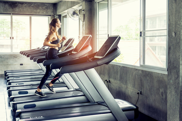 A woman is running on a treadmill.