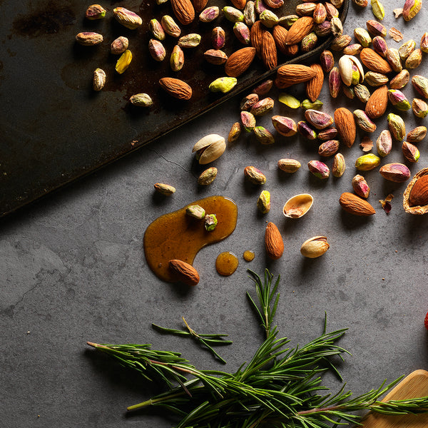 Fresh almonds and other nuts are spread out on a table.