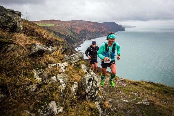 Two runners are running up a mountain.