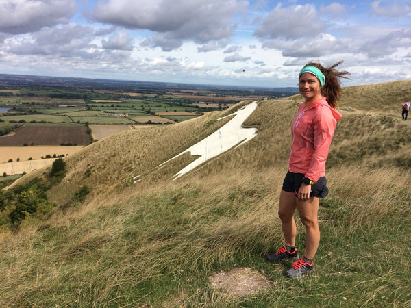 Anna Marie Watson - Ultra marathon runner standing on a mountain and looking at the camera.