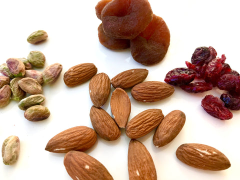 Almonds, nuts, and other fruits are spread out on the table. 