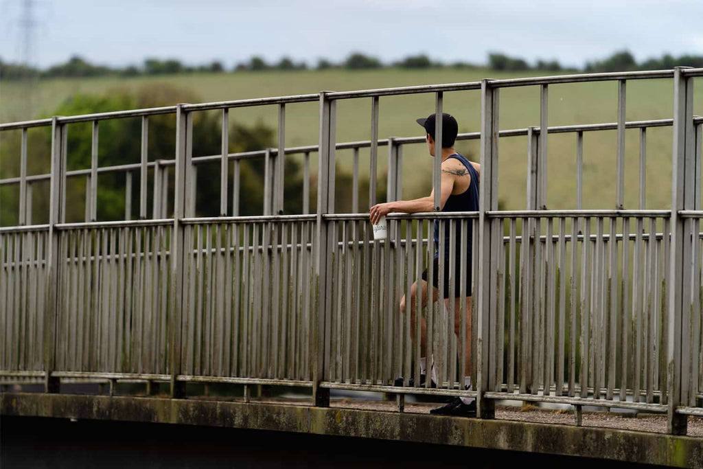 man running and resting on bridge