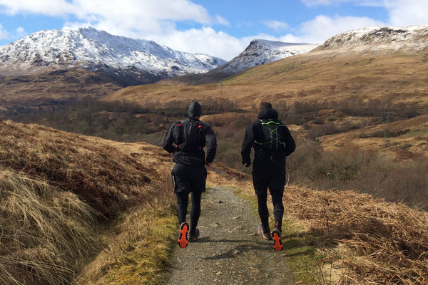 Twee mensen rennen richting de bergen.