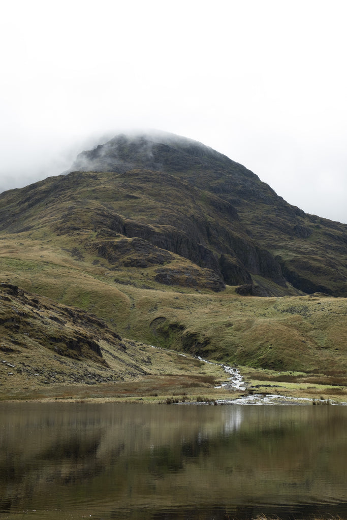 A mountain with a lake and misty weather.