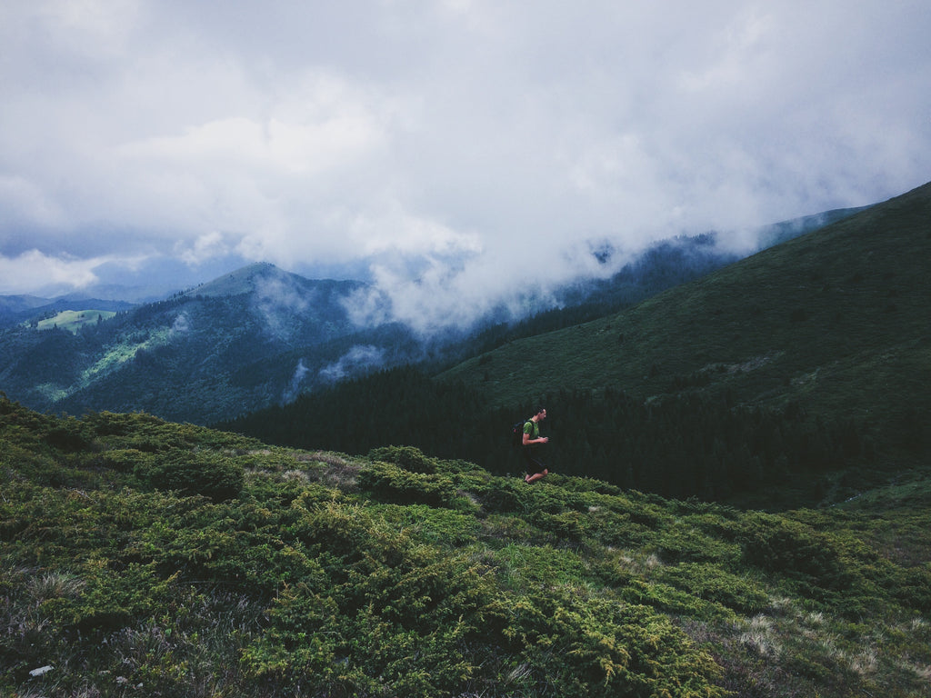 A fell runner is running down the hills.