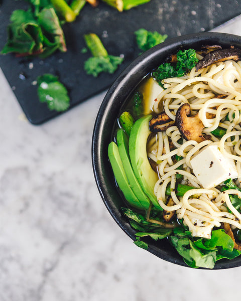 Noodles, mushrooms and veggies in a bowl .