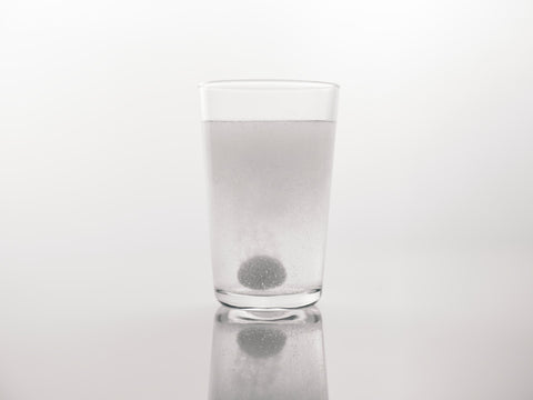 a supplement is dissolving in a glass of water in this Health By Principle blog about fat-soluble and water-soluble vitamins.