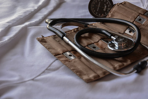a blood pressure cuff and a stethoscope on top of a hospital bed