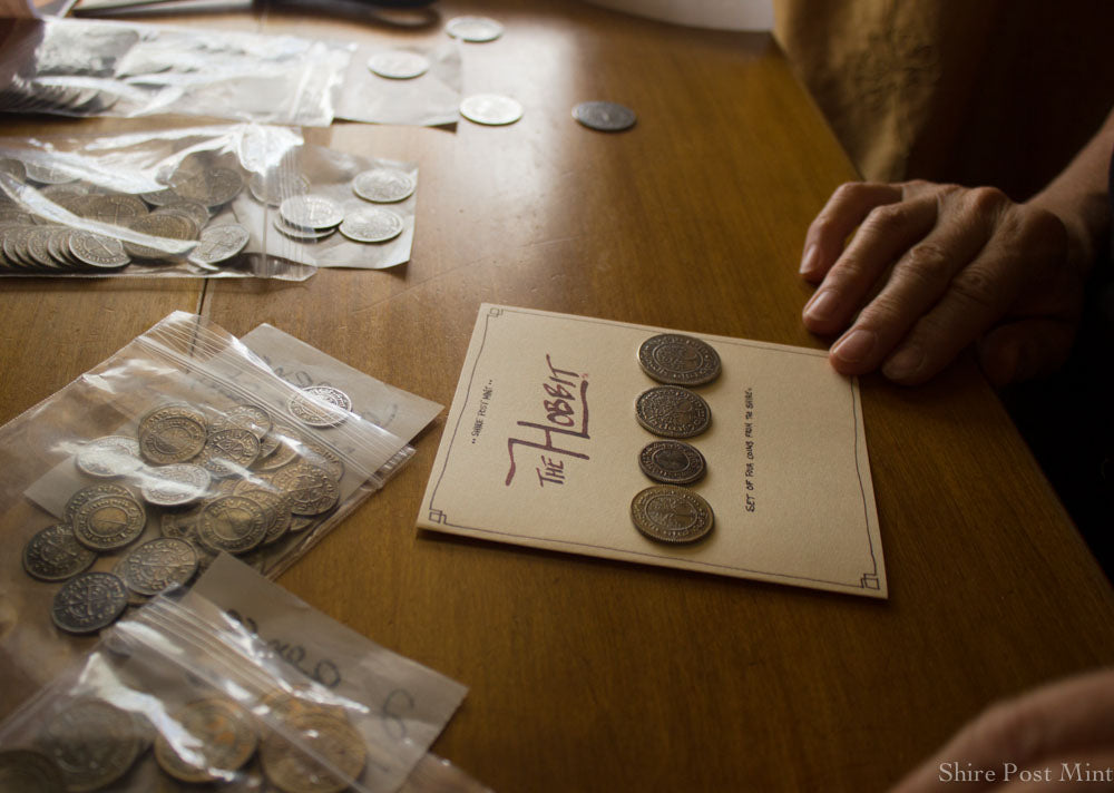 The Hobbit Set #2 being packaged onto a card with history and translations of each coin