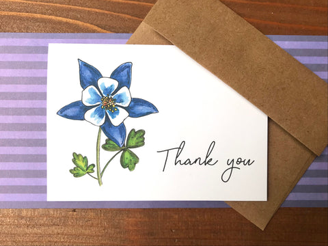 a blue columbine flower note cards sitting on a wood background