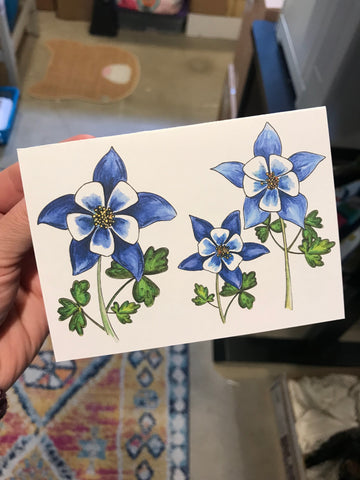 an illustration of blue columbine flowers on a note card