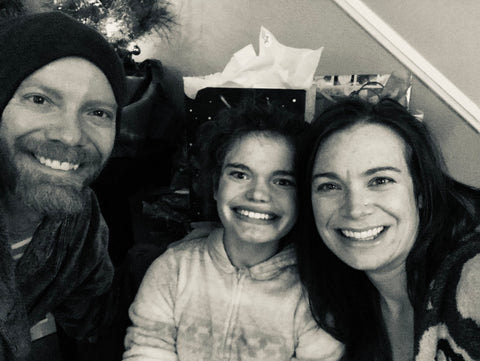 A black and white photo of a man, woman and child smiling.