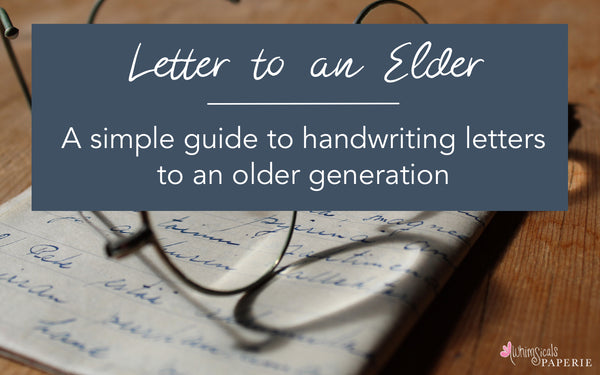 a handwritten letter on a desk with a pair of glasses, text reads Letter to an Elder, a simple guide to handwriting letter to an older generation