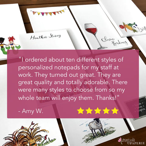 Notepads lying on a wooden surface with a review stating: "I ordered about ten different styles of personalized notepads for my staff at work. They turned out great. They are great quality and totally adorable. There were many styles to choose from so my whole team will enjoy them. Thanks!"
