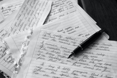 a stack of handwritten letters on white lined paper