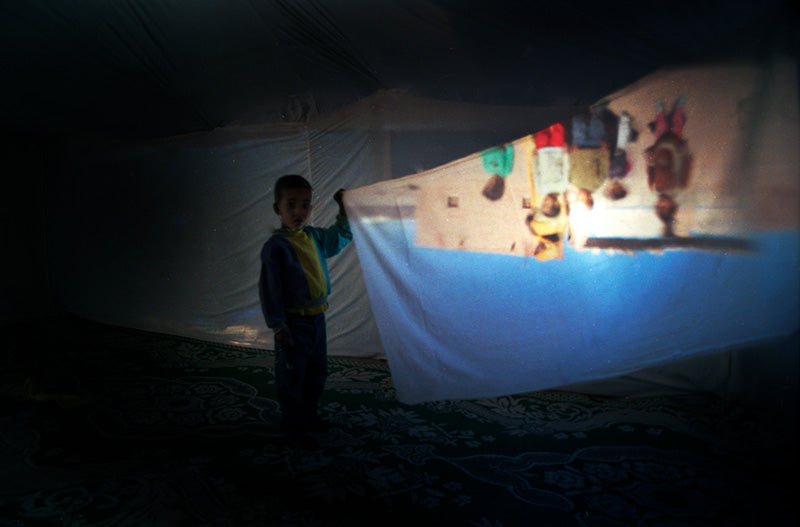 Schoolboy holding a projection. Camera Obscura project Western Sahara refugee camps 2004. Nilufar Nuthall