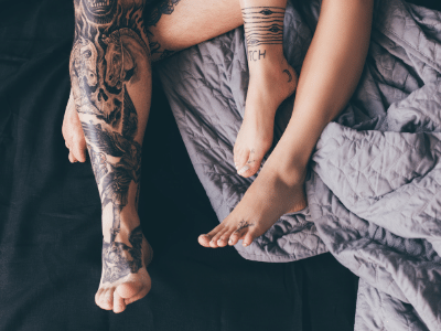 tattooed couple in bed