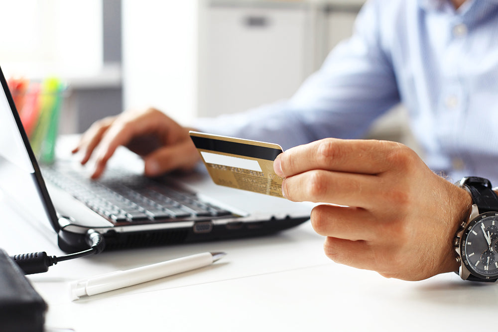 Man using credit card to purchase something online via e-commerce.