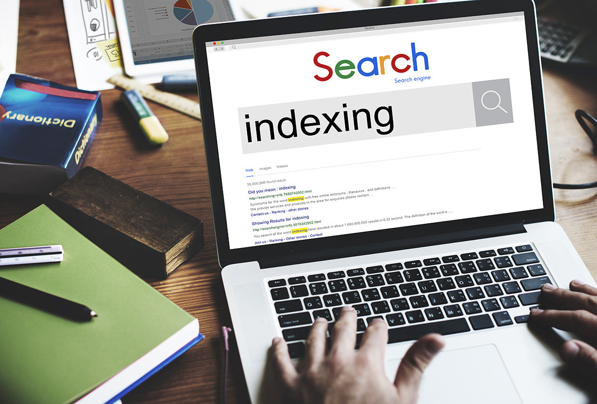 Person searching "Indexing" in Google Search on a laptop at desk