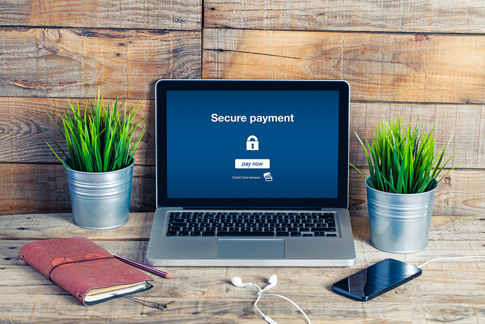 A laptop on a desk with a secure payment method message on the screen eases the user about the business's secure payment methods. 