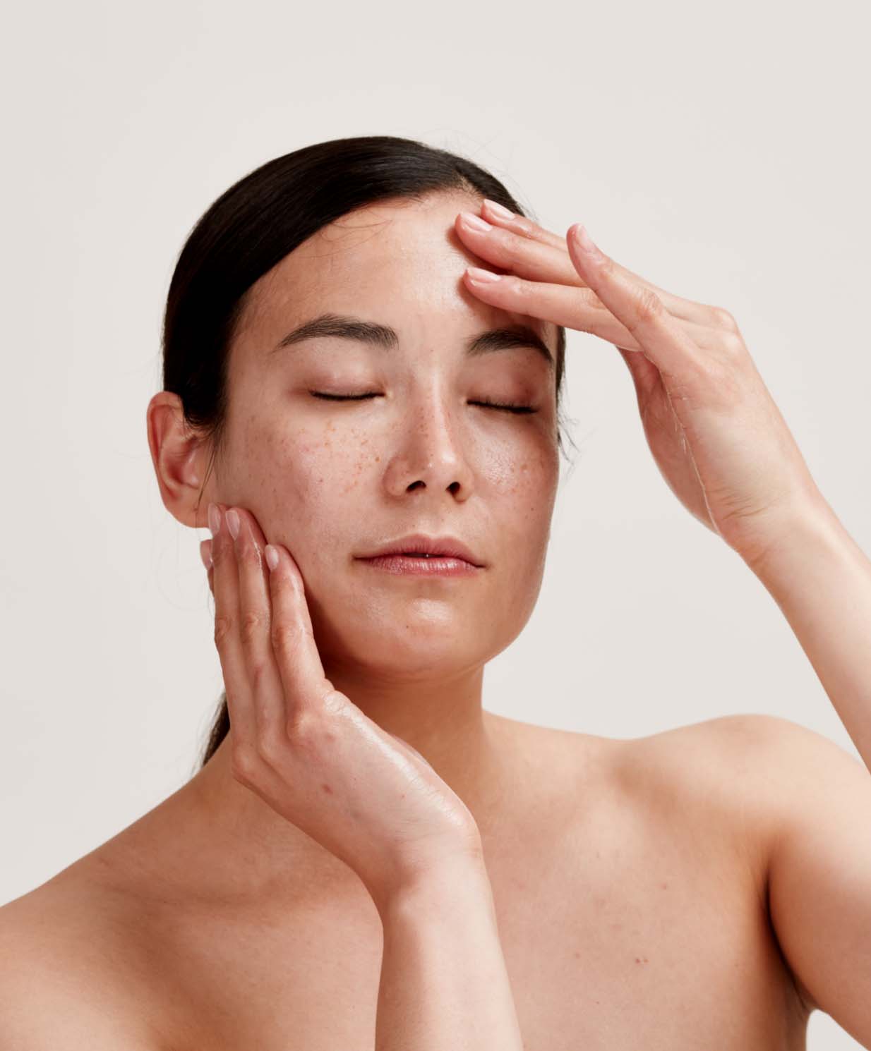 woman applying skincare to face