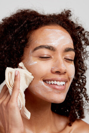 woman using cloth to remove exfoliator