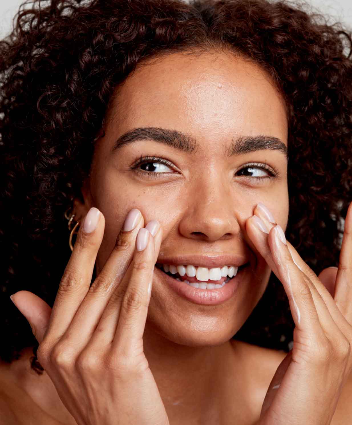 happy woman applying skincare