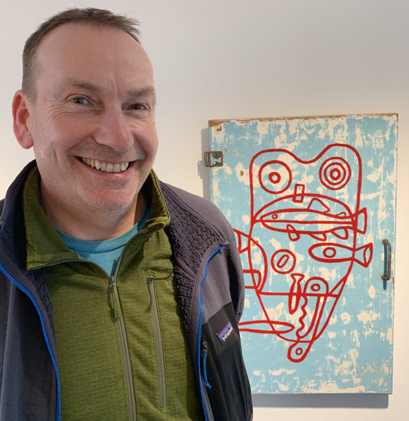 Smiling man standing next to Orkney artwork