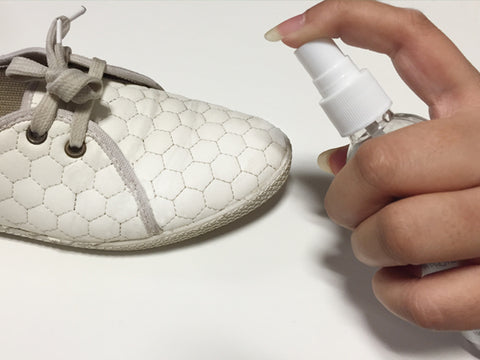 Spraying Vetro Power on a pair of shoes.