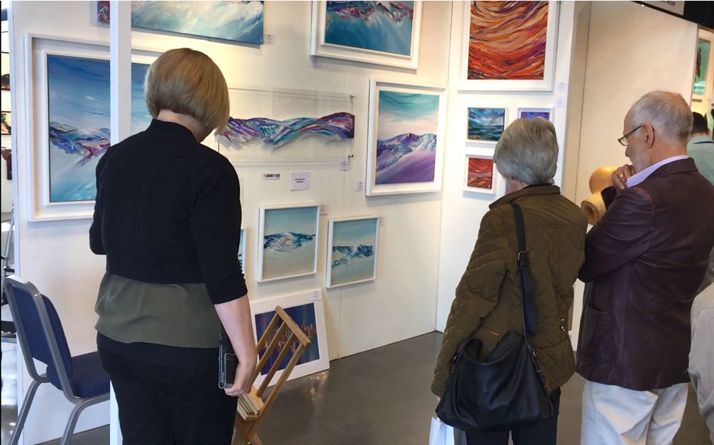 Artist Jayne Leighton Herd helping art collectors at an art fair