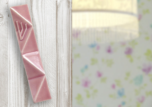 A pink ceramic Mezuzha in Shira's nursery room