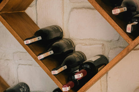 A close up of wine bottles in a wine rack. This wine storage is under stairs.