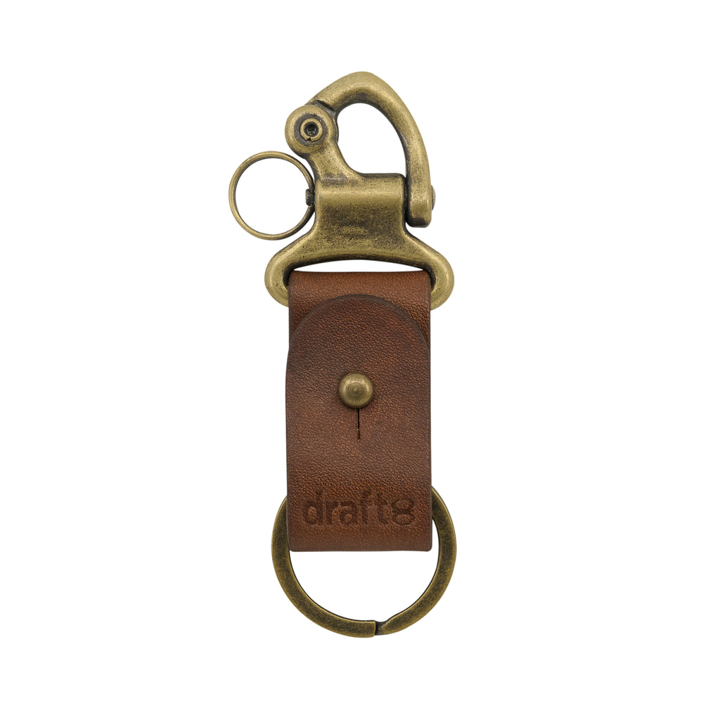 Small brass hook on leather strap. Maybe a bottle opener and what