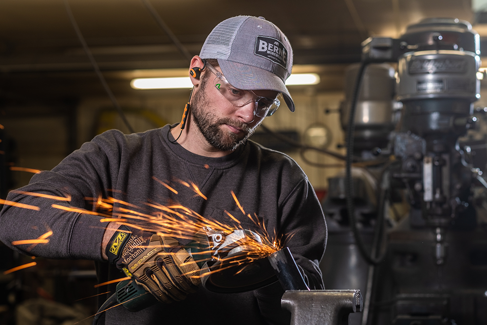 Man wears ISOtunes PRO 2.0 to protect his hearing while working on a loud project