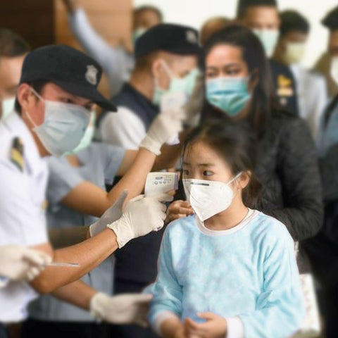 Border staff checking peoples temperature with laser temperature gun