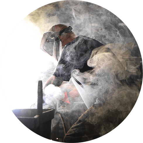 man welding in smoke