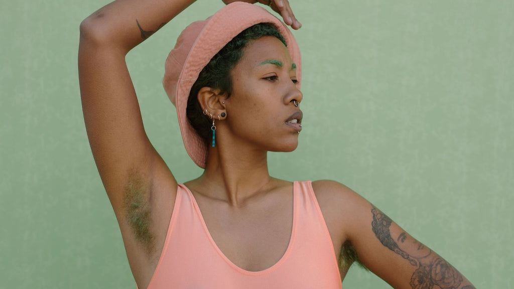 A black woman showing her armpit with hair and discoloration