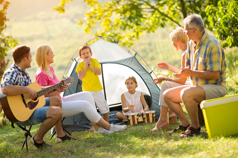 Family singing around campsite