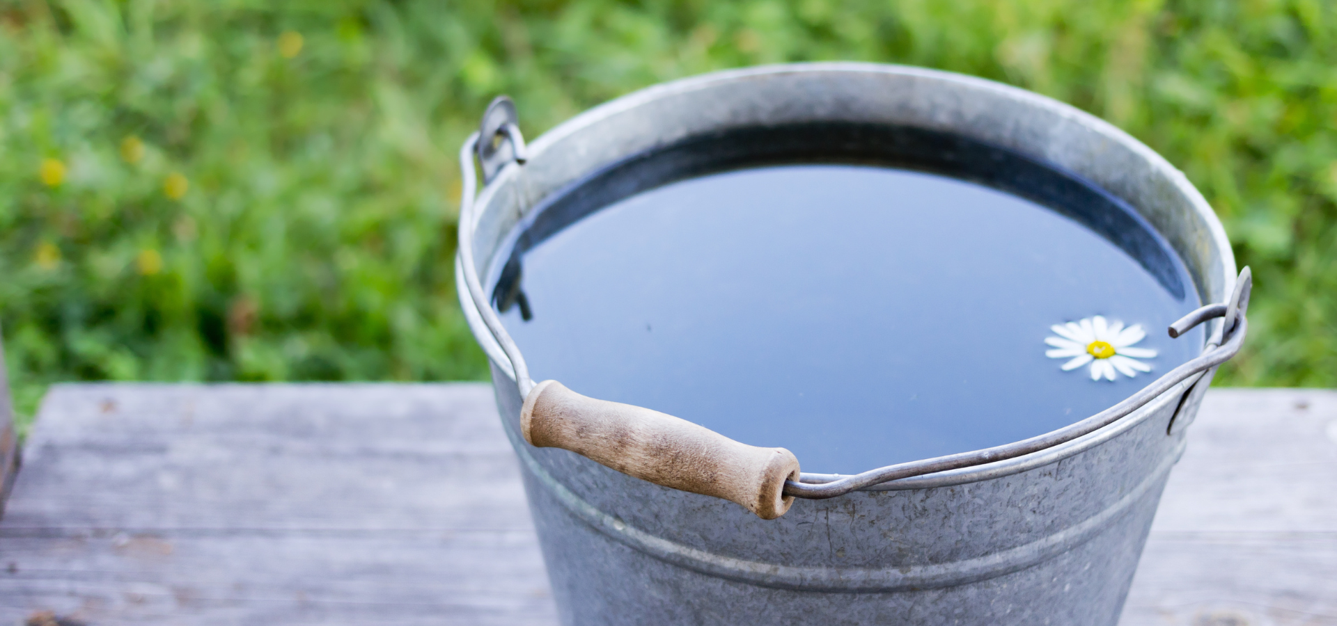 A filled bucket of water sat on a wooden deck